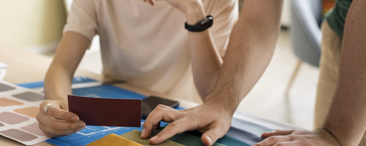 un homme et une femme qui choisissent une couleur de textile